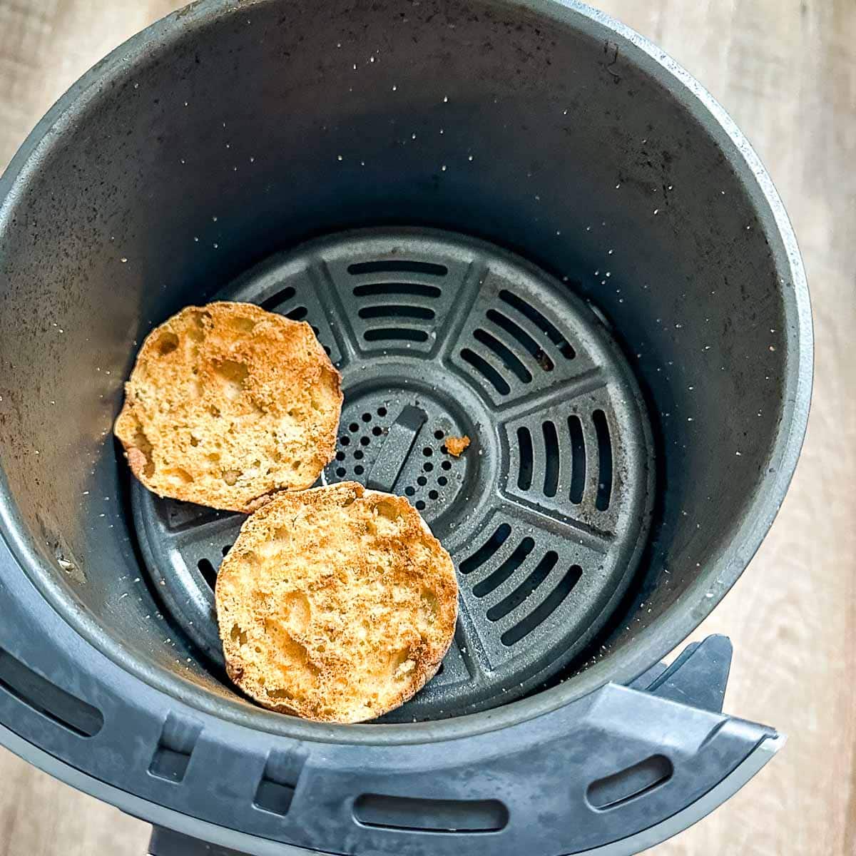 Air fried English muffins in air fryer basket.