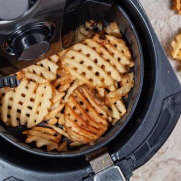 waffle cut fries in the air fryer basket.