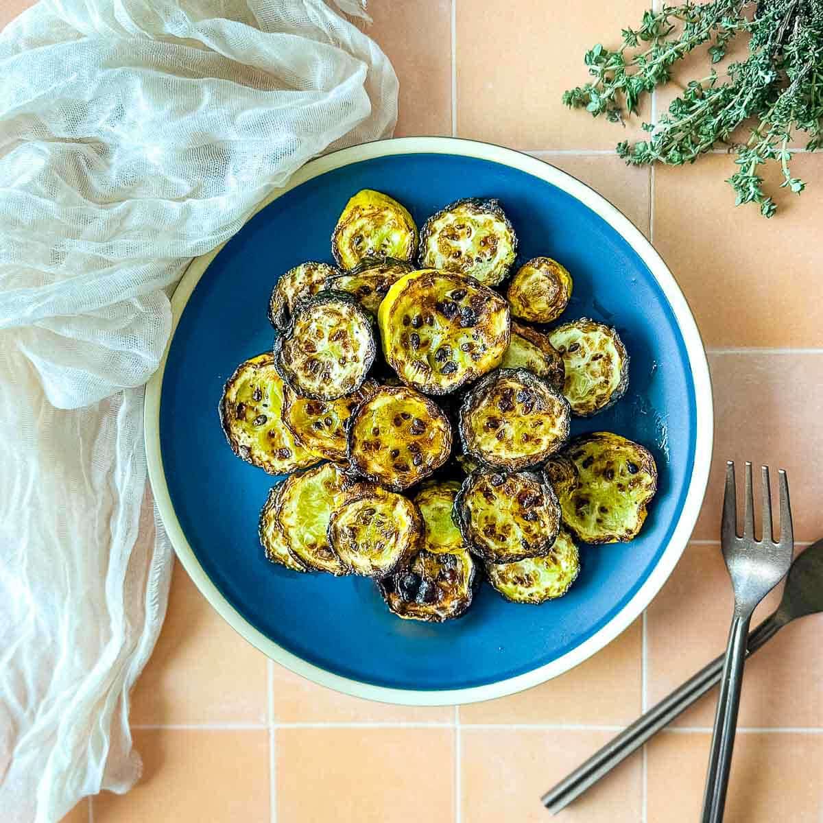 Air fryer zucchini and squash on a blue plate.