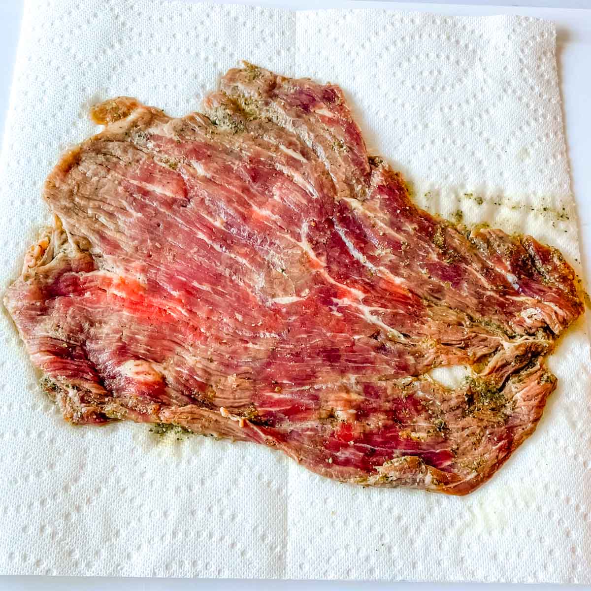 Marinated carne asada on a paper towel.