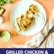 Sliced grilled chicken on a white plate with crema with the words grilled chicken with lime crema displayed and the web address for two cloves kitchen dot com.