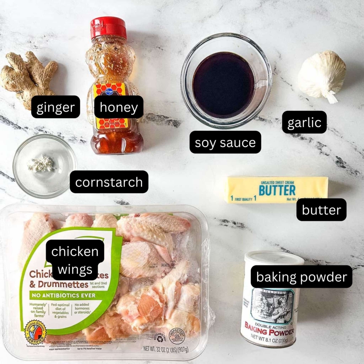 The labeled ingredients for soy garlic chicken wings sit on a white marble counter.