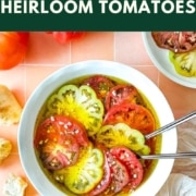 Marinated tomato slices in a pie dish with the words marinated heirloom tomatoes and the web address two cloves kitchen dot com.