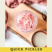Pickled shallots in a glass jar with the words Quick Pickled Shallots and the web address two cloves kitchen dot com.