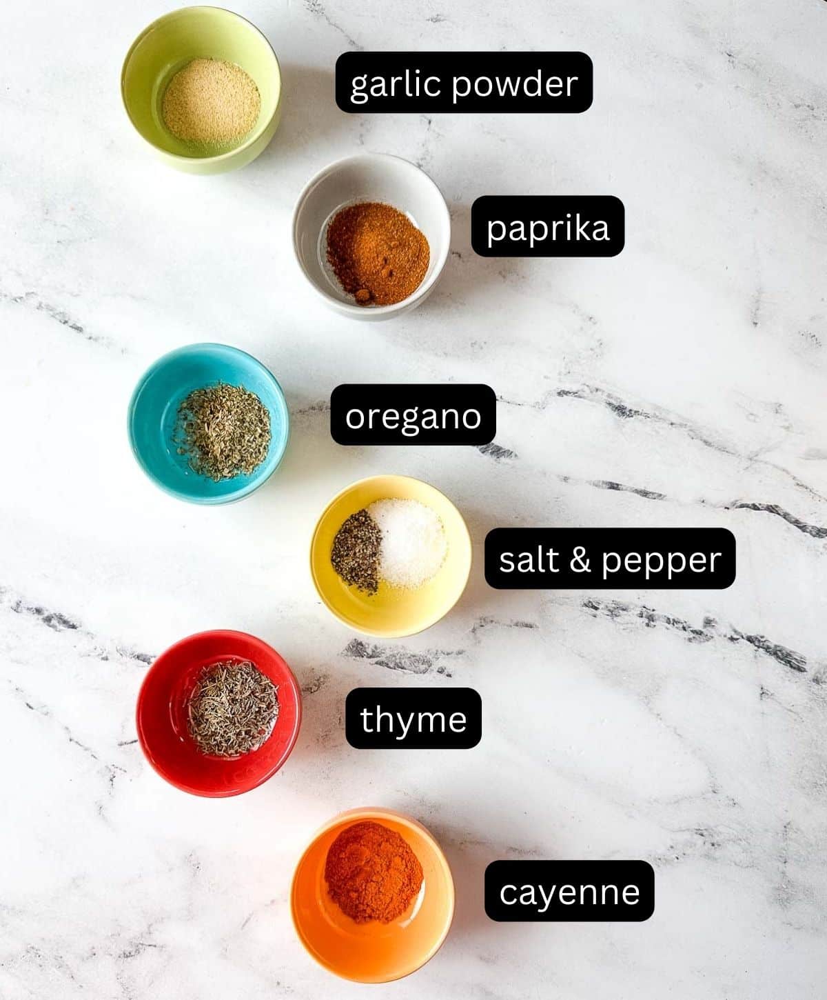 Labeled ingredients for blackening spice on a white marble counter.