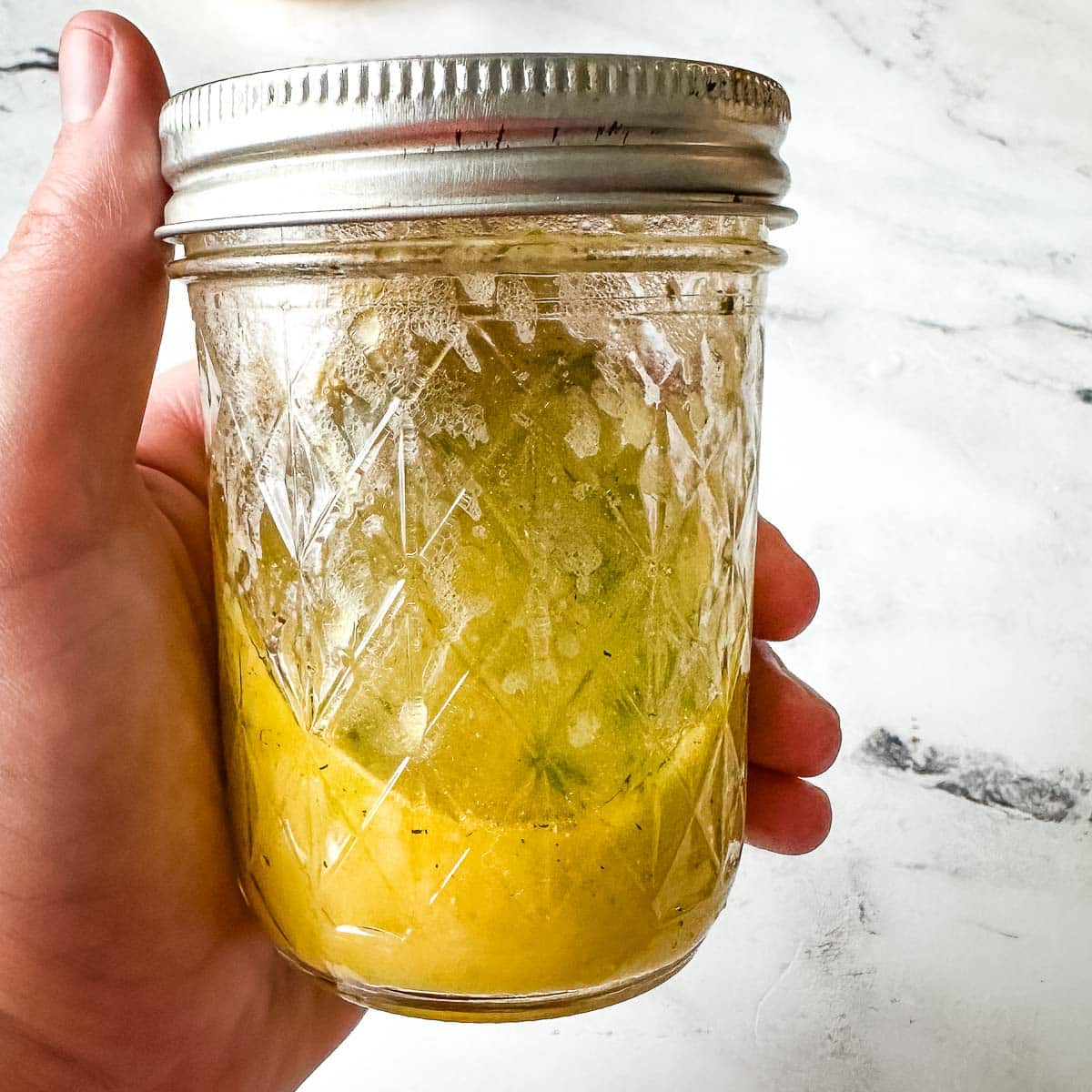 Lemon vinaigrette in a glass jar.