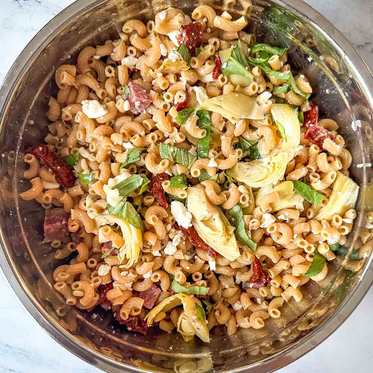 Whole wheat pasta salad in a metal bowl.