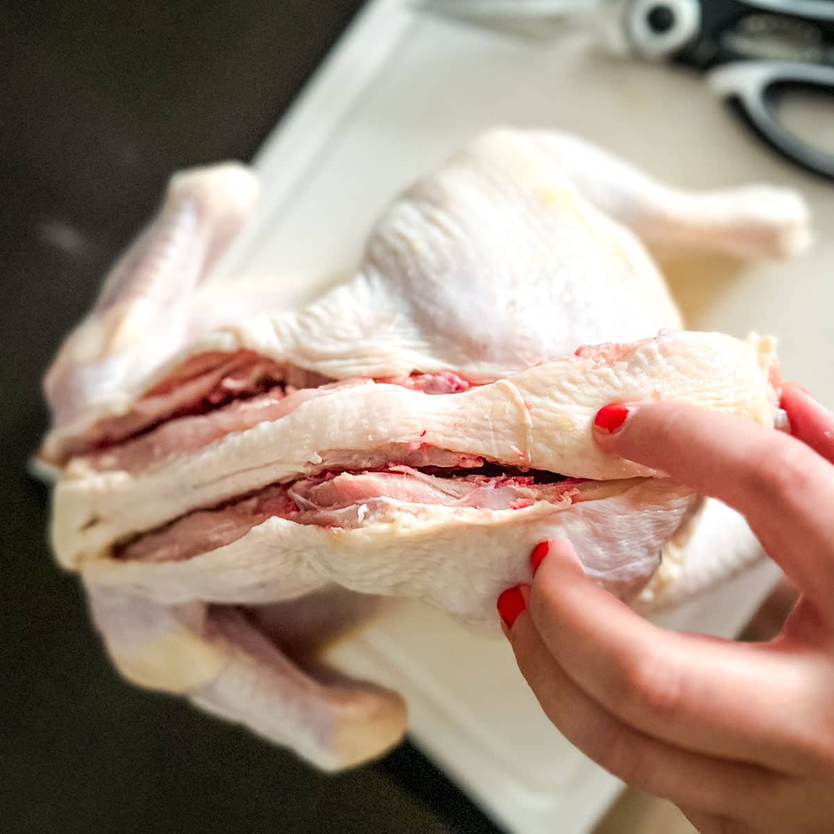 The backbone of a chicken is removed.