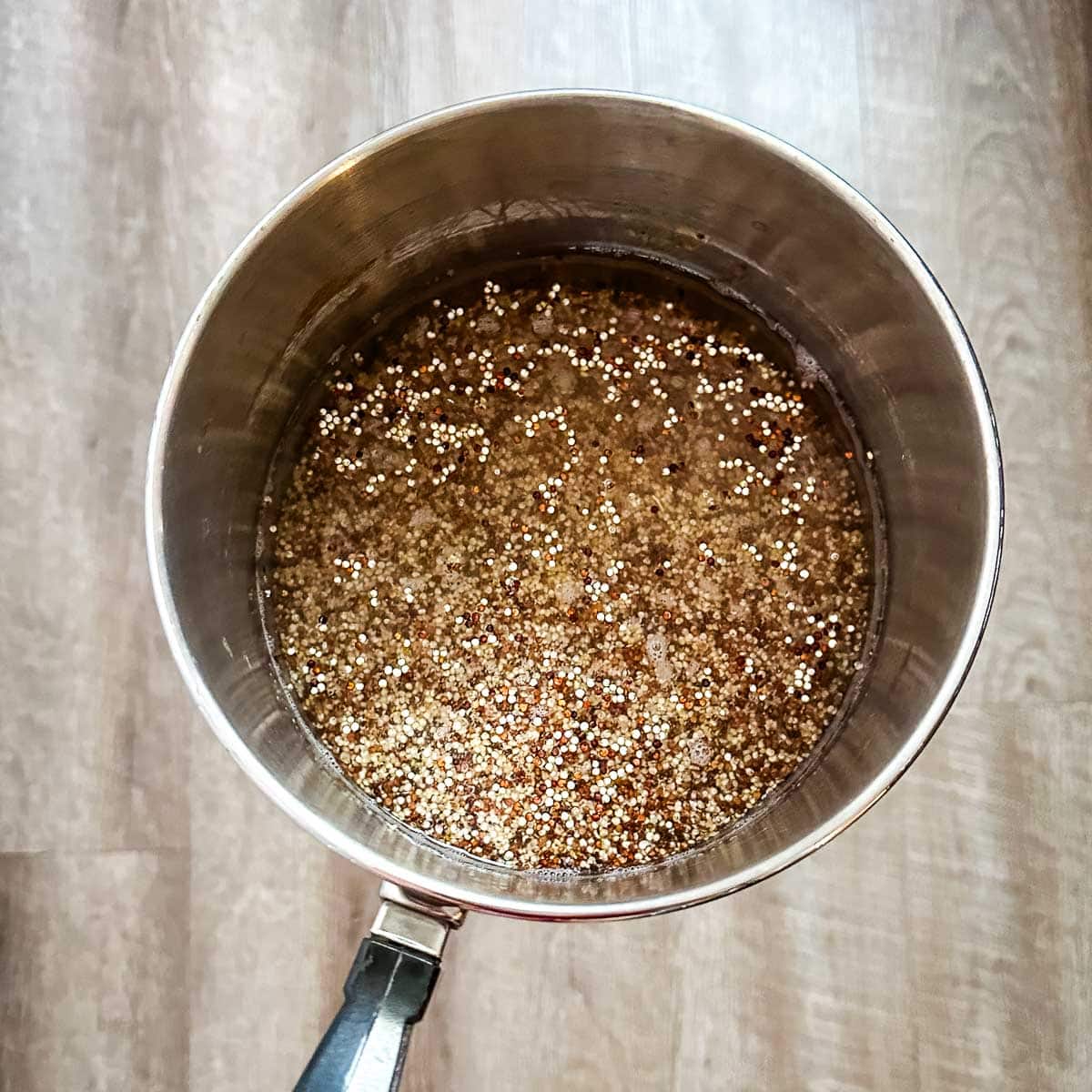 Quinoa and water in a silver pot.