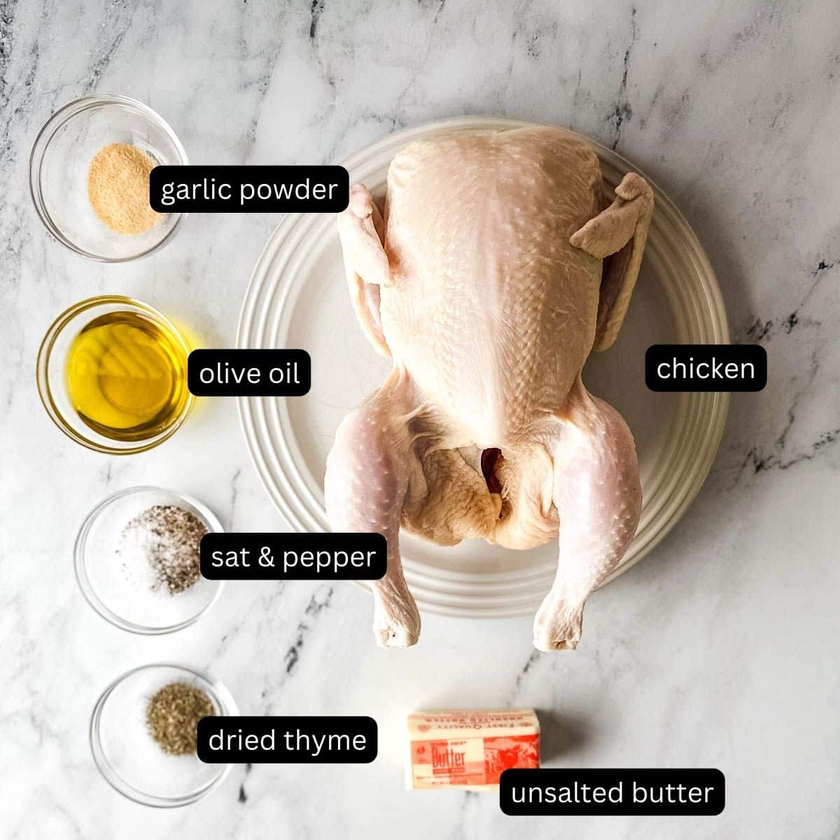 The labeled ingredients for roasted half chicken on a white marble counter.