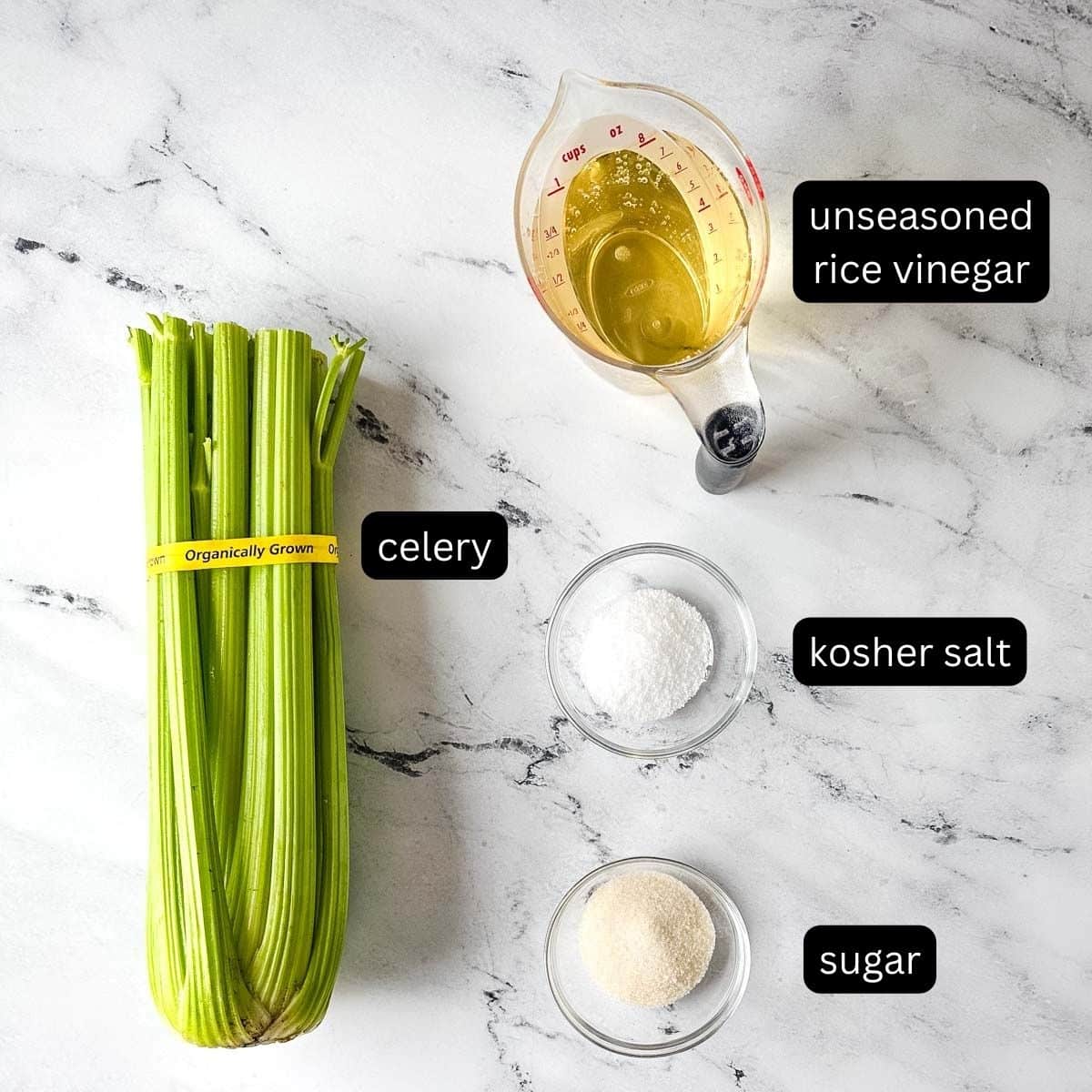 Ingredients for pickled celery on a marble countertop.