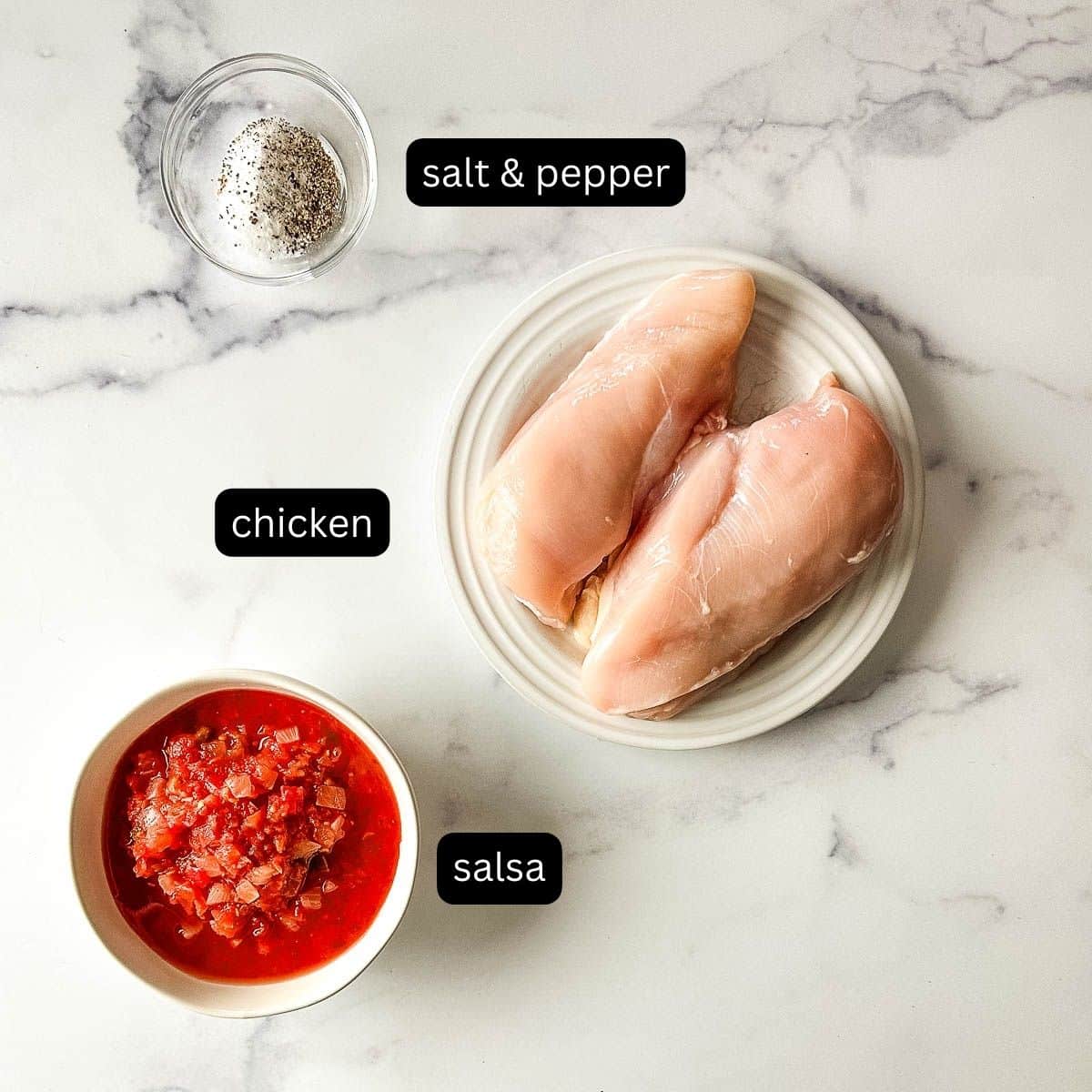 The ingredients for slow cooker salsa chicken on a marble table.