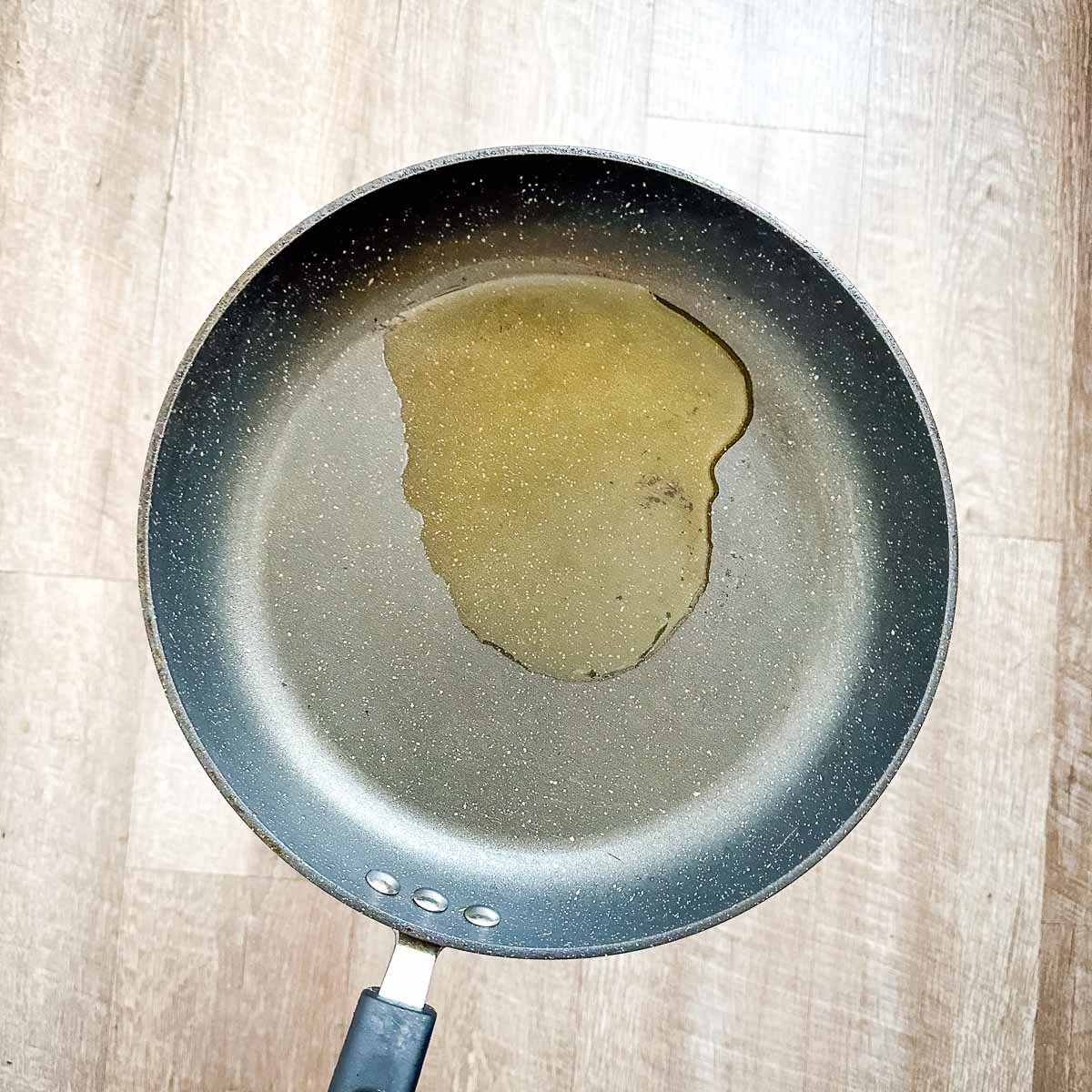 A frying pan with a drop of oil in it.