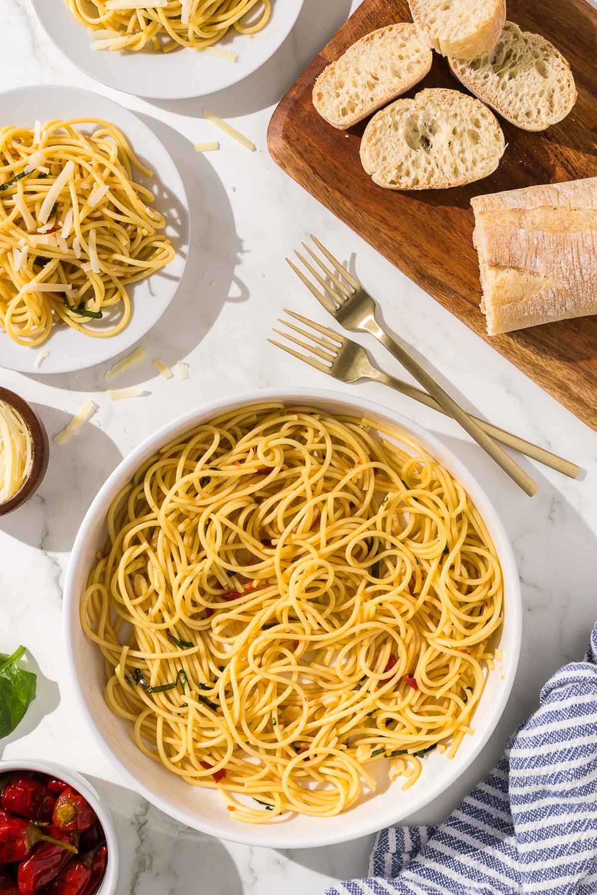 A plate of spaghetti and bread on a marble table.