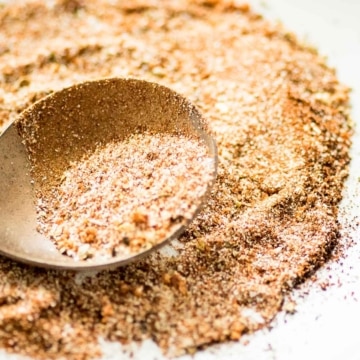 A spoonful of taco seasoning on a white plate.