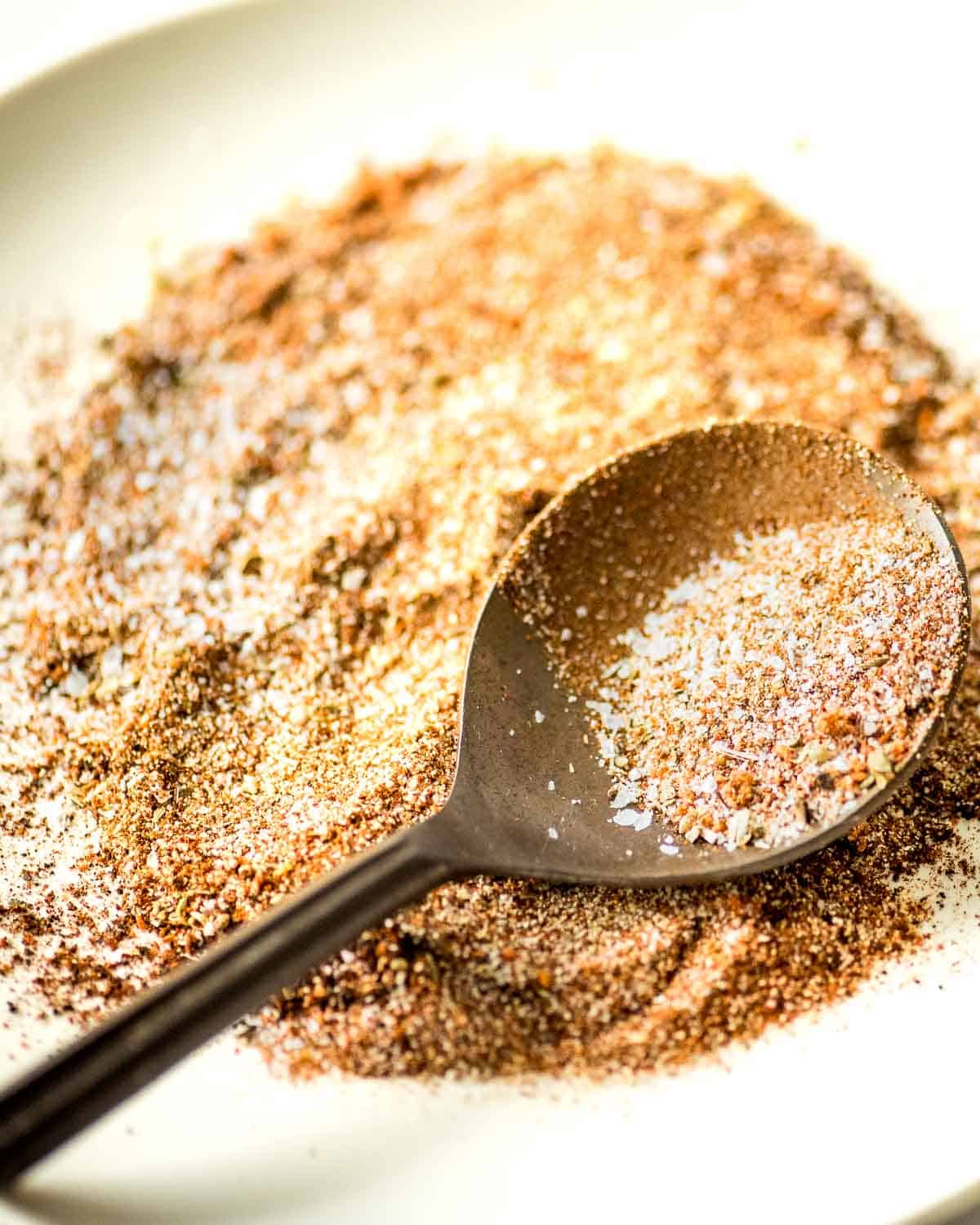 A spoonful of taco seasoning on a white plate.