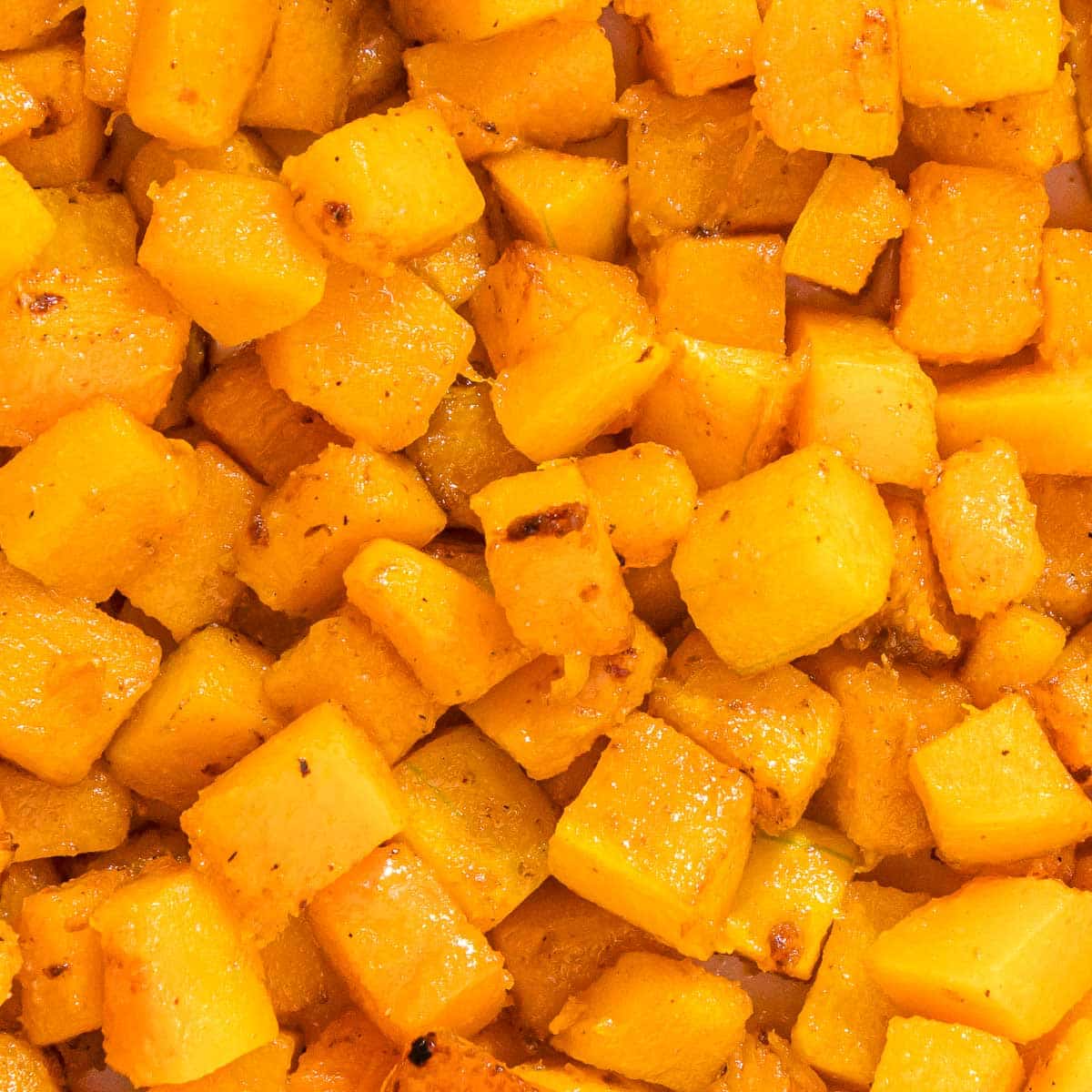 A close up of roasted butternut squash cubes.
