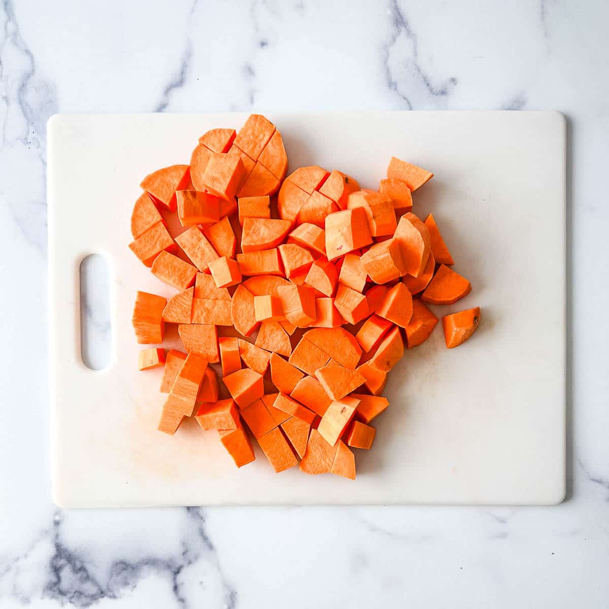 Cubed sweet potatoes on a cutting board.