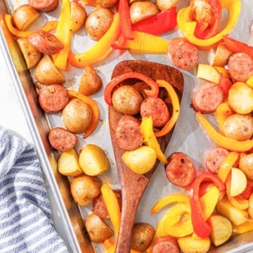 A baking sheet filled with roasted potatoes, chicken sausage and bell peppers.