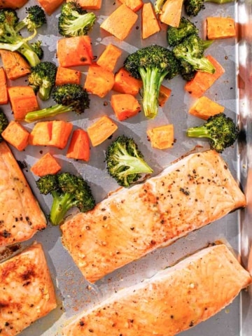 Salmon and vegetables on a baking sheet.