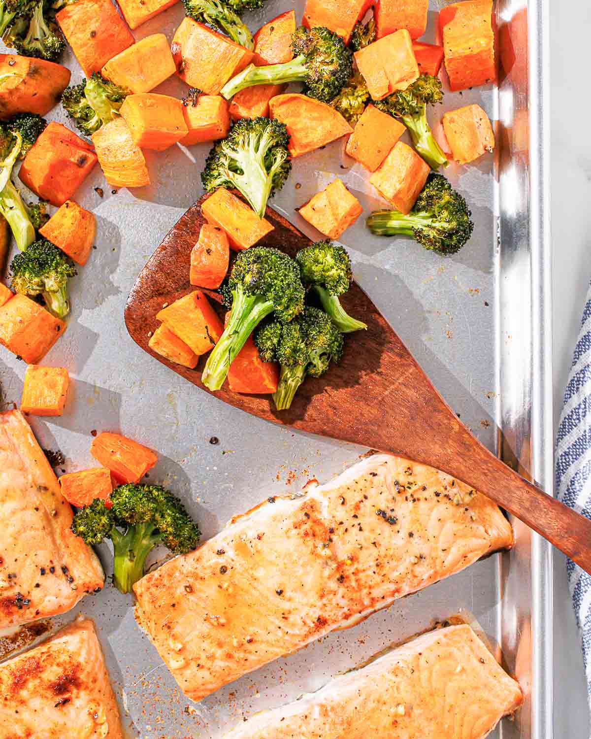 Salmon and vegetables on a baking sheet.