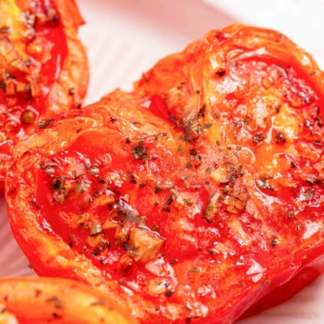 Air fryer tomatoes on a white plate.