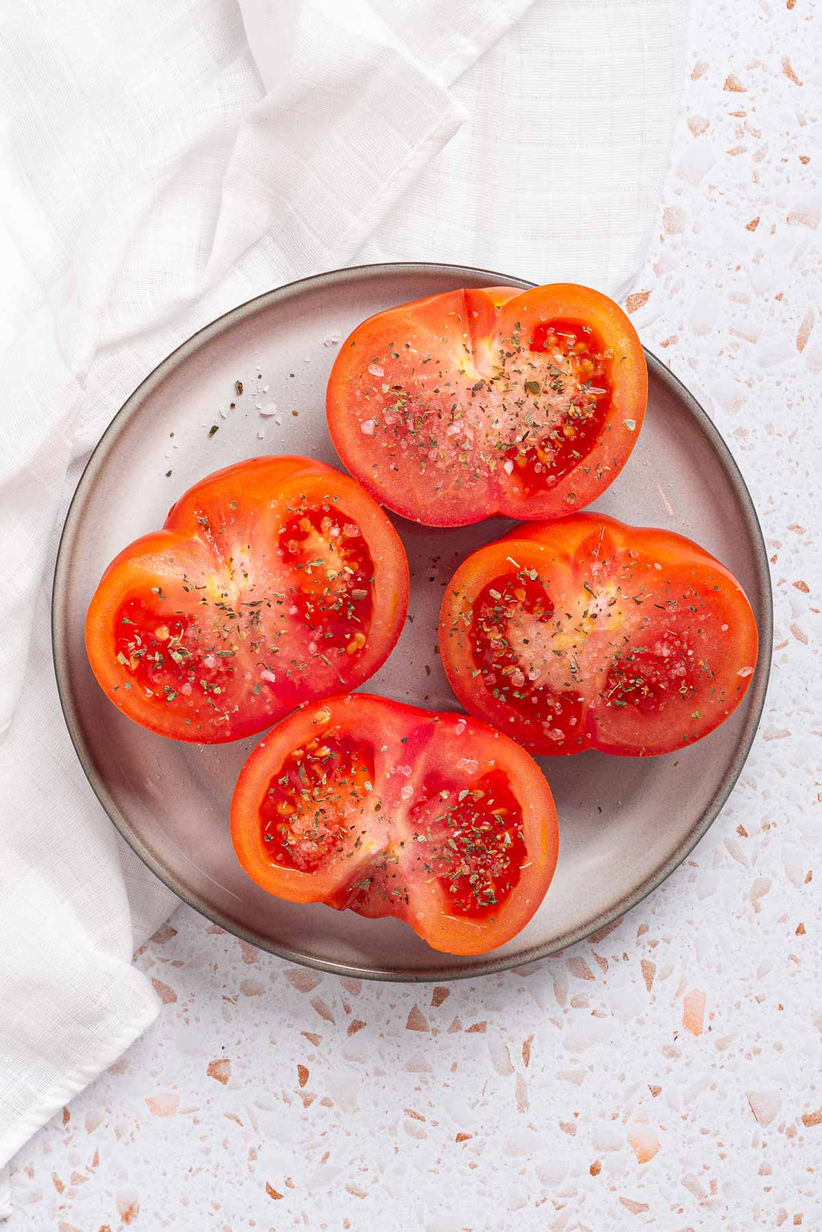 Sliced tomatoes on a plate on a white background.