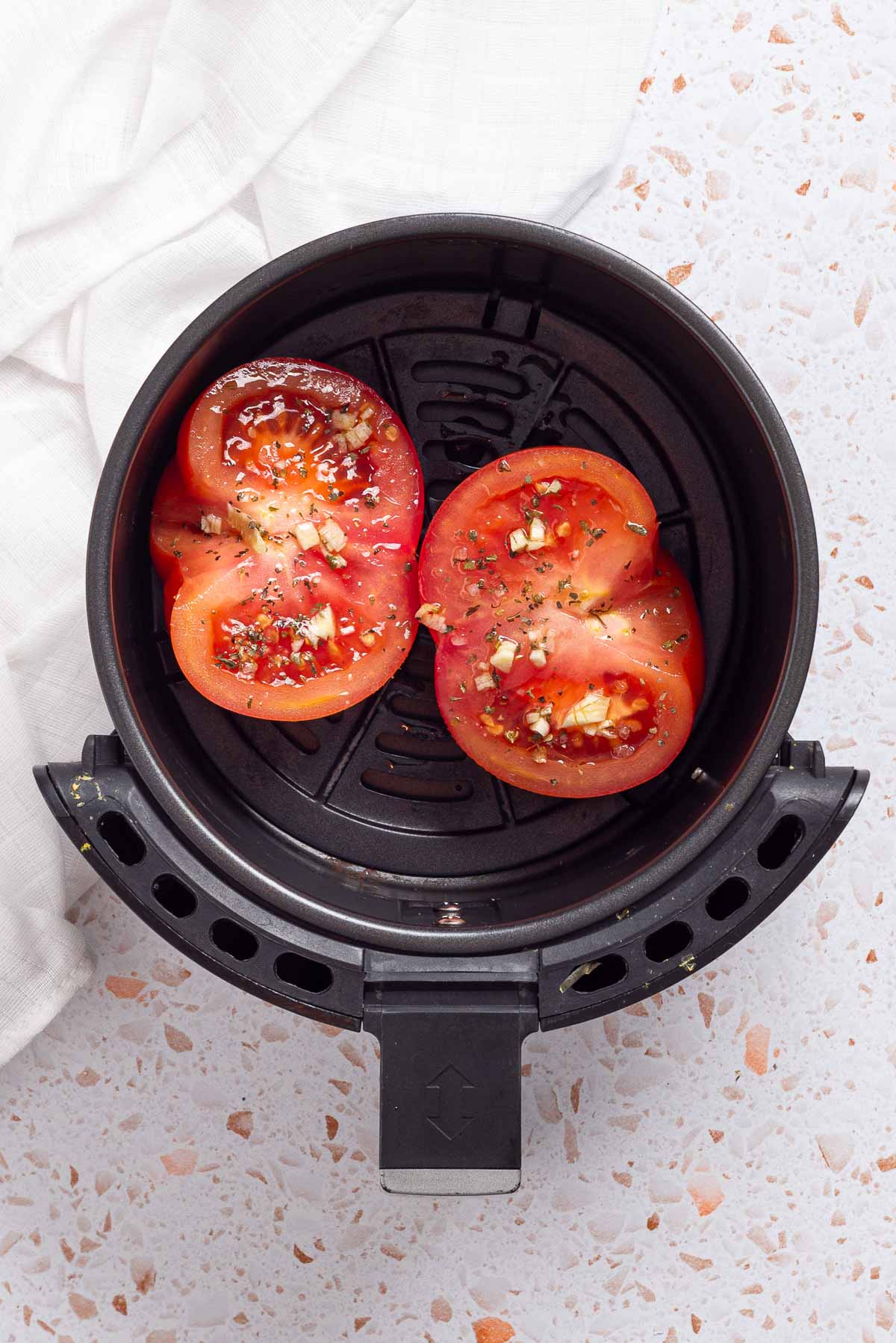 An air fryer with tomatoes in it.