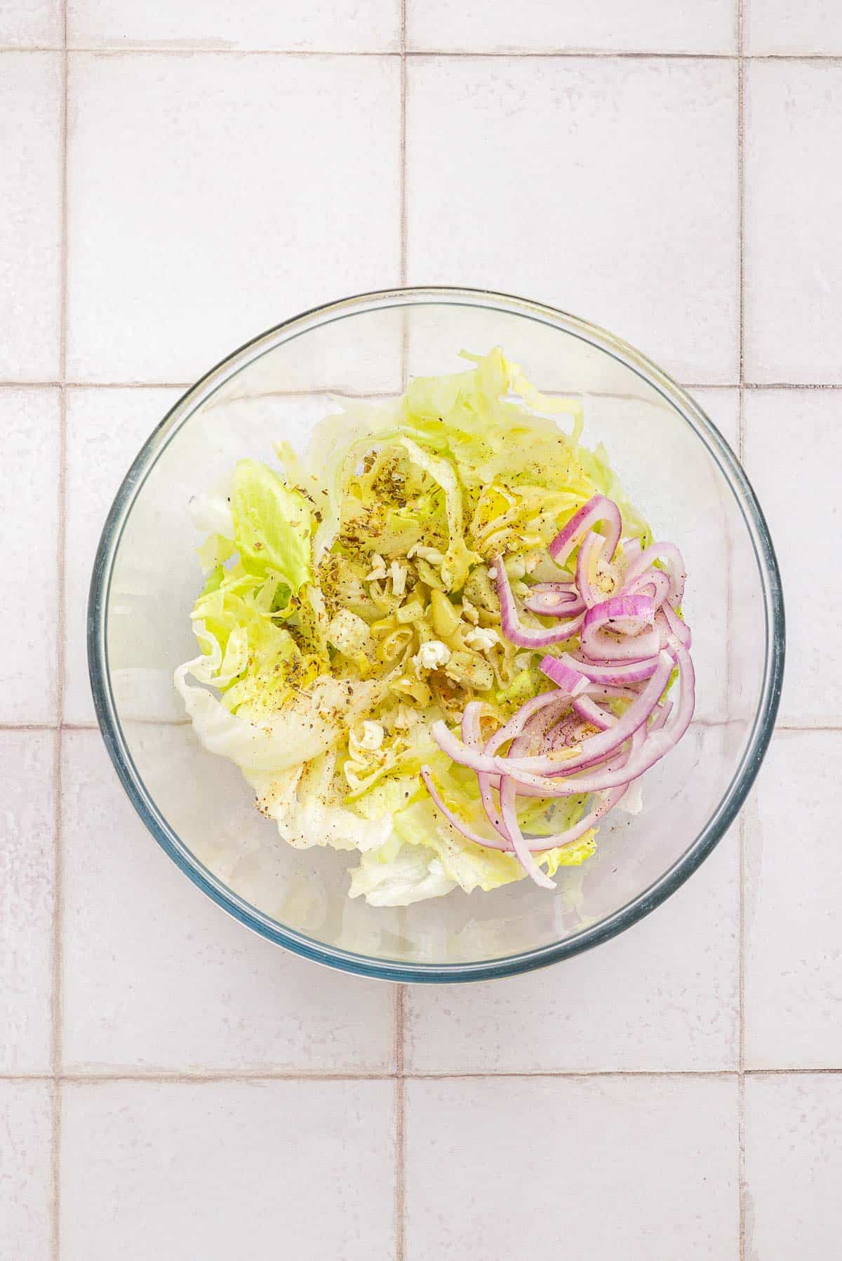 A bowl of salad with onions and spices.