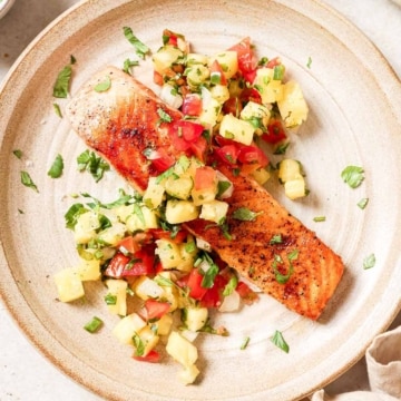 Salmon with pineapple salsa on a plate.