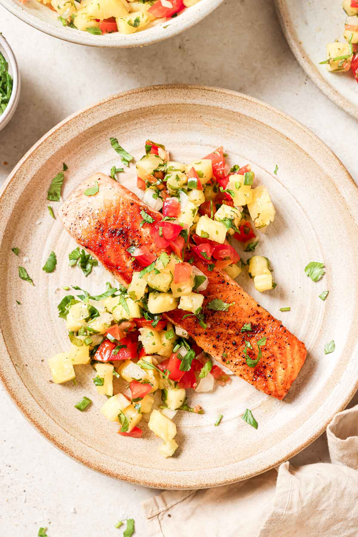 A plate of salmon with a pineapple salsa.