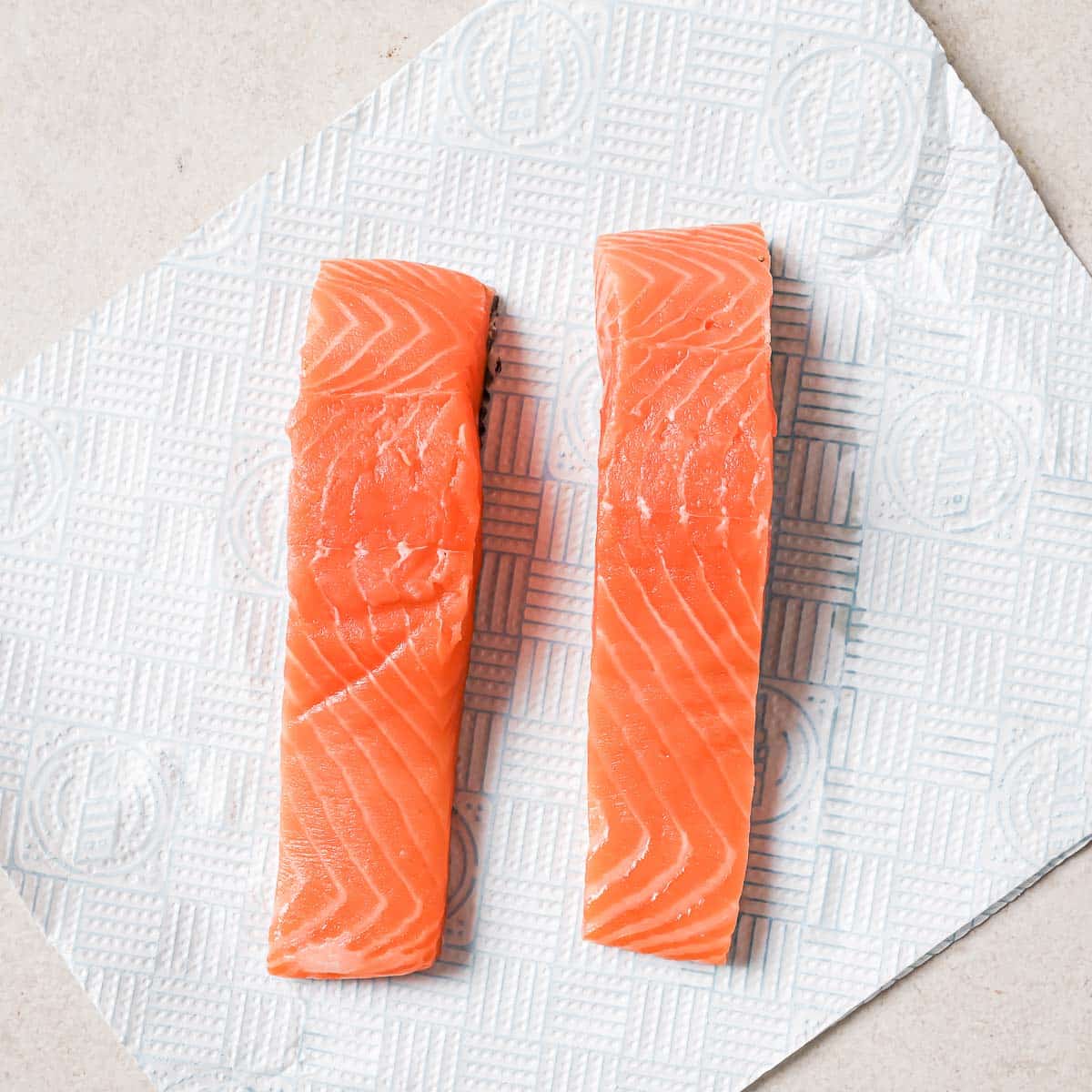 Two pieces of salmon on a piece of paper.