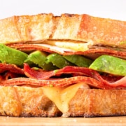 A turkey avocado sandwich with bacon and cheese.
