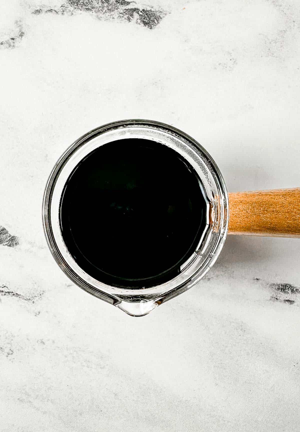 Balsamic glaze in a small glass serving vessel.