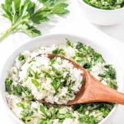 A bowl of chimichurri rice with a wooden spoon.