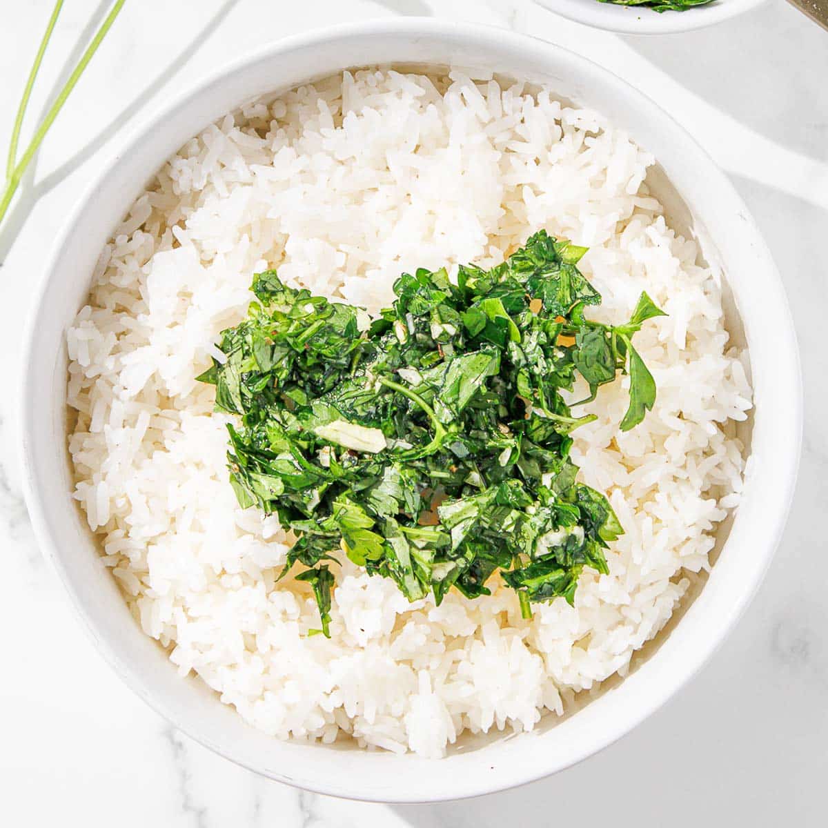 A bowl of rice with chimichurri added on top.