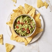 4-ingredient guacamole and chips on a white plate.