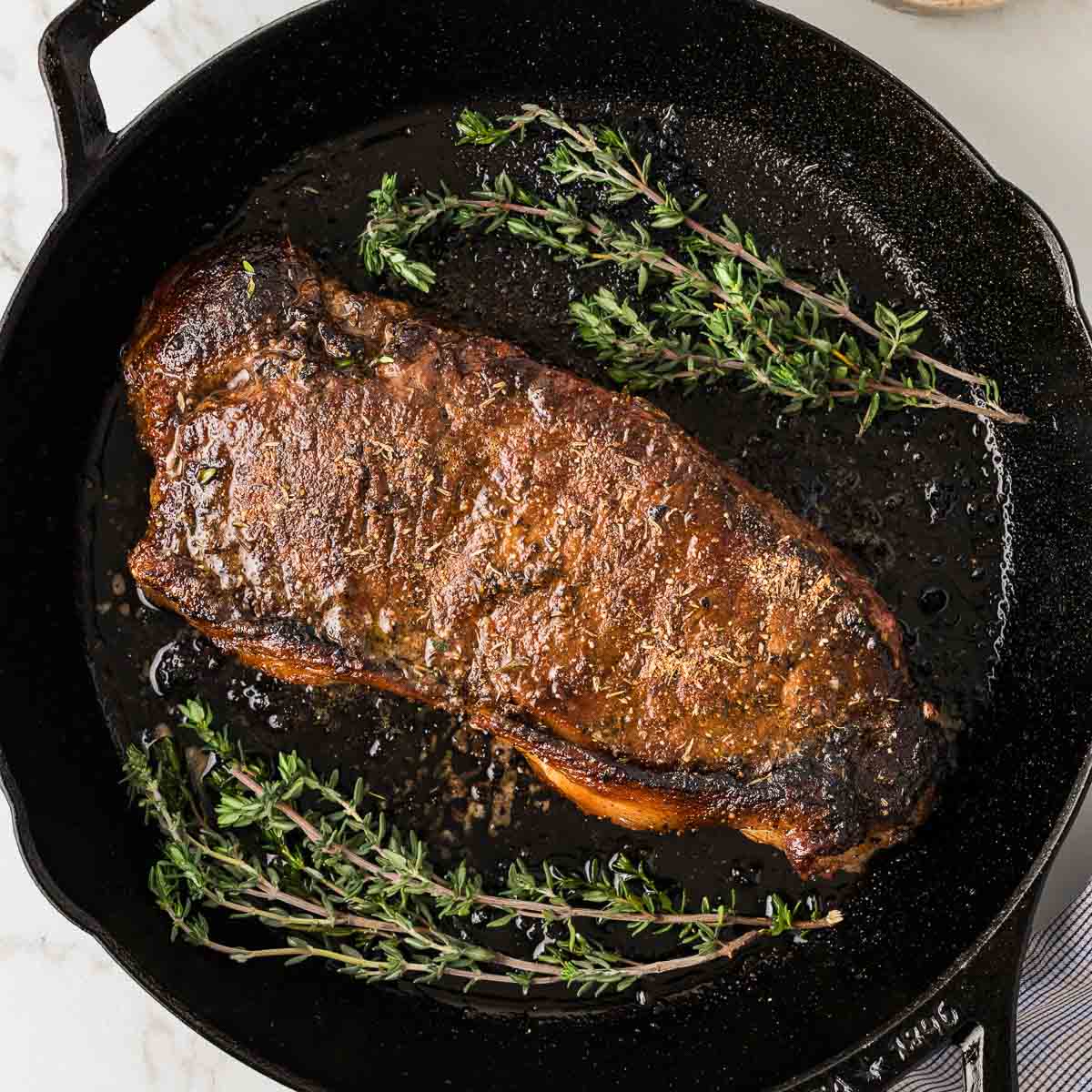 A blackened steak in a cast iron skillet.