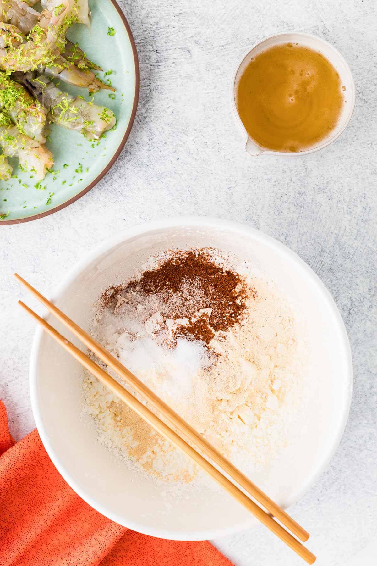 The dry ingredients for beer batter in a dish with chopsticks.