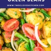 Close-up of Italian potato salad with green beans, cherry tomatoes, onion slices, and herbs, topped with a banner showing the dish name and website.